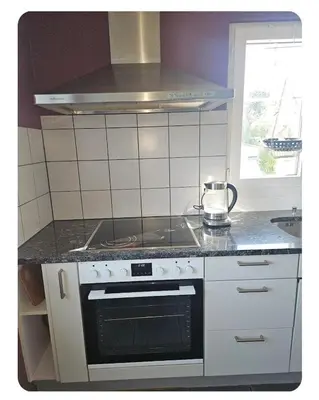 a kitchen with a stove top oven in a kitchen at Holzchalet mit Garten und Terrasse in Egnach