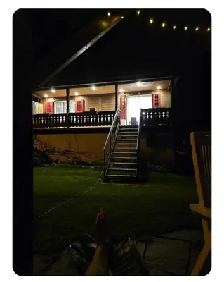 a house with stairs and a porch at night at Holzchalet mit Garten in Egnach
