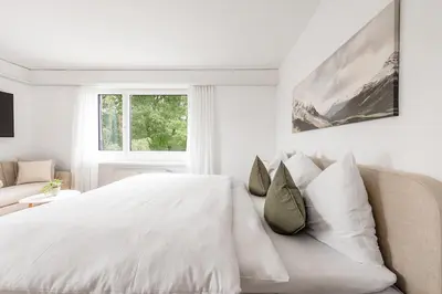 a white bedroom with a bed and a couch at SOHO3A !Gratis Parken, Free Parking! in Kreuzlingen