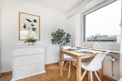 a dining room with a wooden table and white chairs at SOHO3A !Gratis Parken, Free Parking! in Kreuzlingen