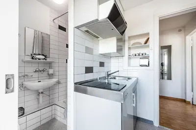 a white bathroom with a sink and a mirror at SOHO3A !Gratis Parken, Free Parking! in Kreuzlingen