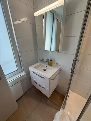 a white bathroom with a sink and a mirror at St Gallen City - 5 min vom Bahnhof - Roter Platz in St. Gallen