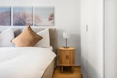 a bedroom with a bed and a table with a lamp at DESIGN-APARTMENT 1 !Gratis parken, Free Parking! in Kreuzlingen