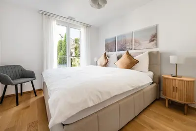 a white bedroom with a large bed and a window at DESIGN-APARTMENT 1 !Gratis parken, Free Parking! in Kreuzlingen