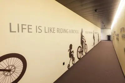 a hallway with a bike wall with the words life is like riding advice at Hotel one66 (free parking garage) in St. Gallen