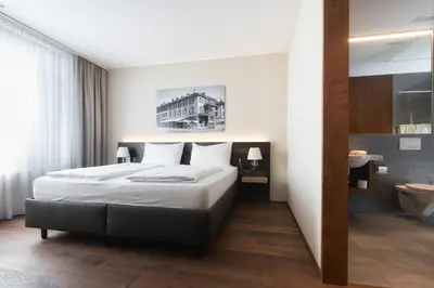 a hotel room with a bed and a bathroom at Hotel one66 (free parking garage) in St. Gallen