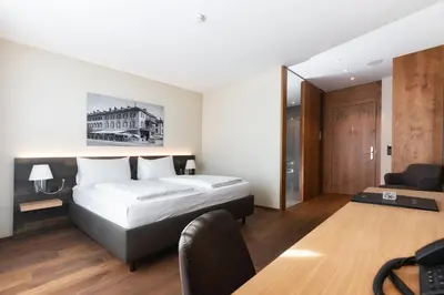 a hotel room with a bed and a desk at Hotel one66 (free parking garage) in St. Gallen