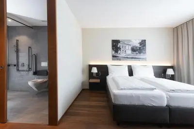 a bedroom with a large bed and a bathroom at Hotel one66 (free parking garage) in St. Gallen