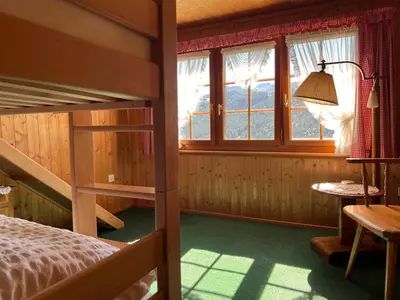 a bedroom with a bunk bed and a window at Beatli Chalet in Wildhaus