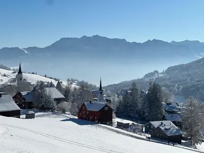 a small village in the snow with mountains in the background at Beatli Chalet in Wildhaus