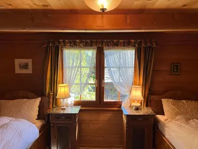 a bedroom with two beds and a window at Beatli Chalet in Wildhaus