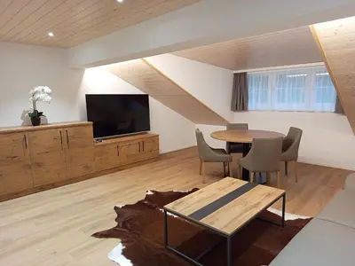 a living room with a table and a flat screen tv at Gästehaus Rossfall 424 - Self-Check-in in Urnäsch