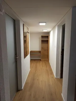 an empty hallway with a door and a wooden floor at Gästehaus Rossfall 424 - Self-Check-in in Urnäsch
