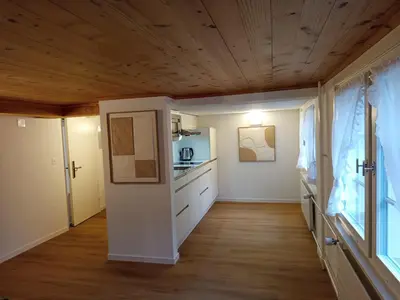 a kitchen with white cabinets and a wooden ceiling at Gästehaus Rossfall 424 - Self-Check-in in Urnäsch