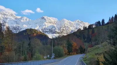 a road in the mountains with snow covered mountains at Gästehaus Rossfall 424 - Self-Check-in in Urnäsch