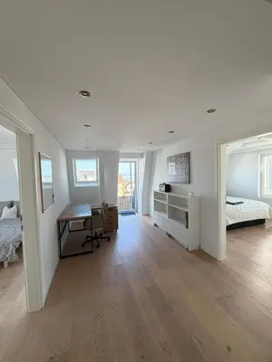 a white room with a desk and a bed at Elegante Maisonette mit See-Panorama in Rorschach in Rorschach