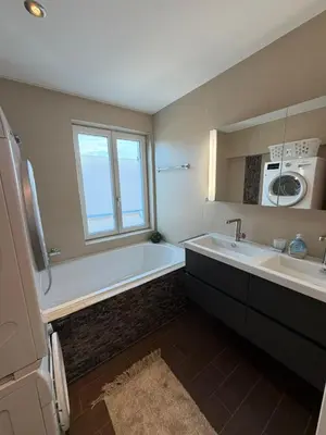 a bathroom with a tub and a sink and a microwave at Elegante Maisonette mit See-Panorama in Rorschach in Rorschach