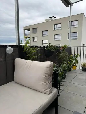 a white pillow sitting on a balcony with a building at Elegante Maisonette mit See-Panorama in Rorschach in Rorschach