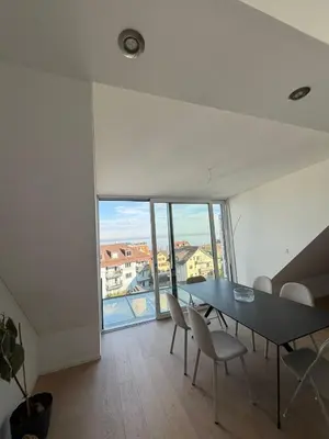 a dining room with a table and chairs and a large window at Elegante Maisonette mit See-Panorama in Rorschach in Rorschach