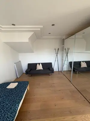 a living room with a couch and a mirror at Elegante Maisonette mit See-Panorama in Rorschach in Rorschach