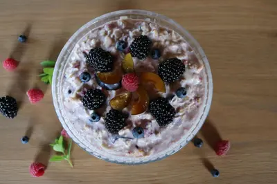 a bowl of overnight oats with fruit and berries at B&B Hofgenuss in Ganterschwil