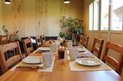 a long wooden table with plates and utensils on it at B&B Hofgenuss in Ganterschwil
