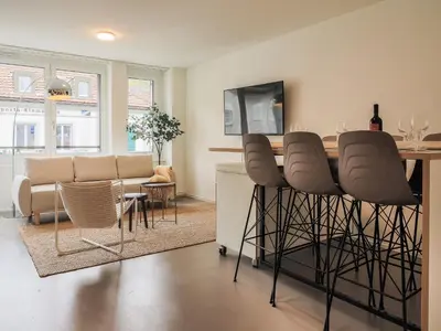 a kitchen and living room with a table and chairs at Stilvoll & zentral in St Gallen -WYBA Living Rio in St. Gallen