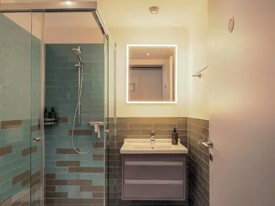 a bathroom with a sink and a shower at Stilvoll & zentral in St Gallen -WYBA Living Rio in St. Gallen