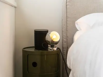 a lamp on a side table next to a bed at Stilvoll & zentral in St Gallen -WYBA Living Rio in St. Gallen
