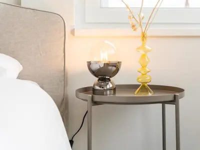 a table with a lamp and a vase on it at Stilvoll & zentral in St Gallen -WYBA Living Rio in St. Gallen