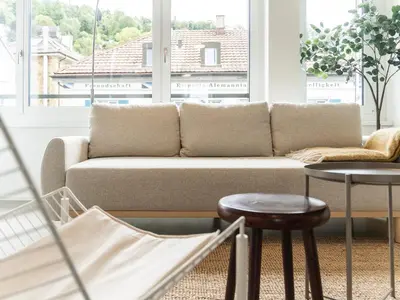 a living room with a couch in front of a window at Stilvoll & zentral in St Gallen -WYBA Living Rio in St. Gallen