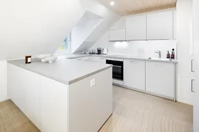 a white kitchen with white cabinets and appliances at BLIV Grosszügiges Altbaujuwel im Zentrum in St. Gallen