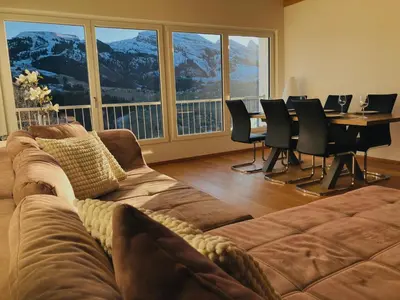 a living room with a couch and a table with chairs at Ferienwohnung mit Sauna in Wildhaus in Wildhaus