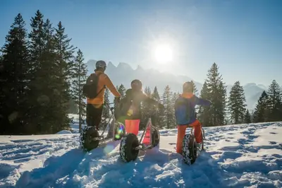 three people standing in the snow with their dirt bikes at Ferienwohnung mit Sauna in Wildhaus in Wildhaus