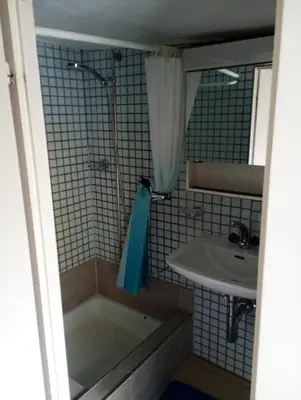 a bathroom with a bath tub and a sink at Central tiny studio in St. Gallen