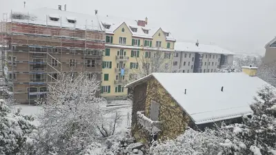 a building covered in snow in a city with buildings at Central studio apartment stgallen gratis Parkplatz in St. Gallen