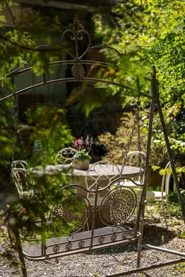 a swing in a garden with flowers in it at Das aussergewöhnliche Gäste- und Ferienhaus in Güttingen