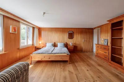 a bedroom with a bed with wooden walls and wooden floors at Das aussergewöhnliche Gäste- und Ferienhaus in Güttingen
