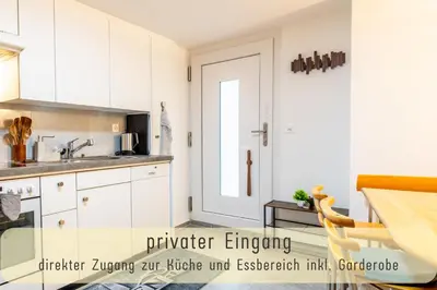 a kitchen with white cabinets and a sink at Gemütliche Souterrainwohnung mit gratis Parkplatz in St. Gallen