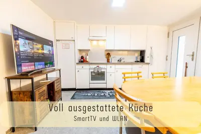 a kitchen and dining room with a table and a tv at Gemütliche Souterrainwohnung mit gratis Parkplatz in St. Gallen