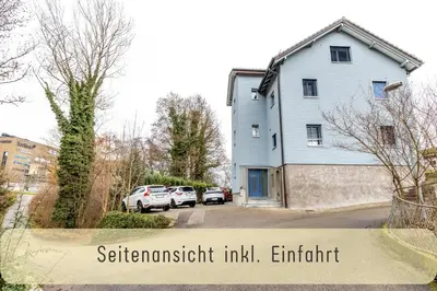 a house with two cars parked in a driveway at Gemütliche Souterrainwohnung mit gratis Parkplatz in St. Gallen