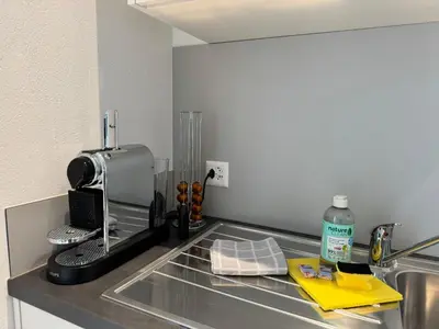 a kitchen counter with a coffee maker on a sink at Alte Näherei in Degersheim
