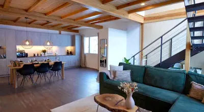 a living room with a green couch and a table at Louisa's Gallery - Modernes Apartment mit Whirlpool und Bergblick - Nahe Piste, Loipe und Wanderparadies im Toggenburg in Alt Sankt Johann