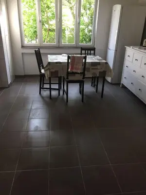 a dining room with a table and chairs on a tile floor at 3 Zi Gartenwohnung in Buchs