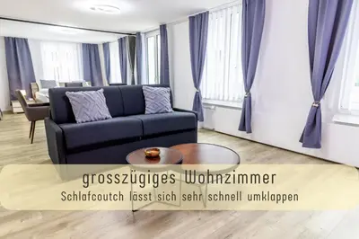 a living room with a couch and a table at Modern 80qm Flat with Balcony & free Parking in St. Gallen