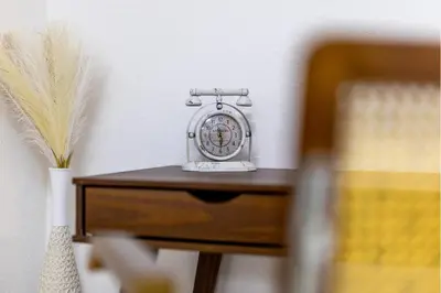 a clock sitting on top of a wooden table at Modern 80qm Flat with Balcony & free Parking in St. Gallen