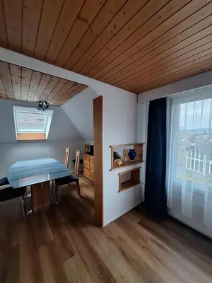 a dining room with a table and a window at Dachwohnung in Niederuzwil