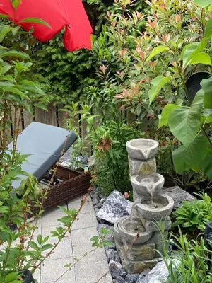 a garden with a stone fountain in the middle at Dachwohnung in Niederuzwil
