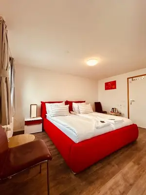 a large red bed in a room with a chair at Romantic Room, Private Bathroom and Great View in Heiden