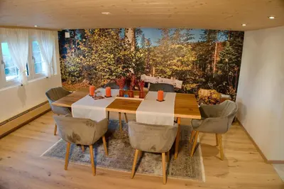 a dining room with a wooden table and chairs at BnB Sonder in Urnäsch